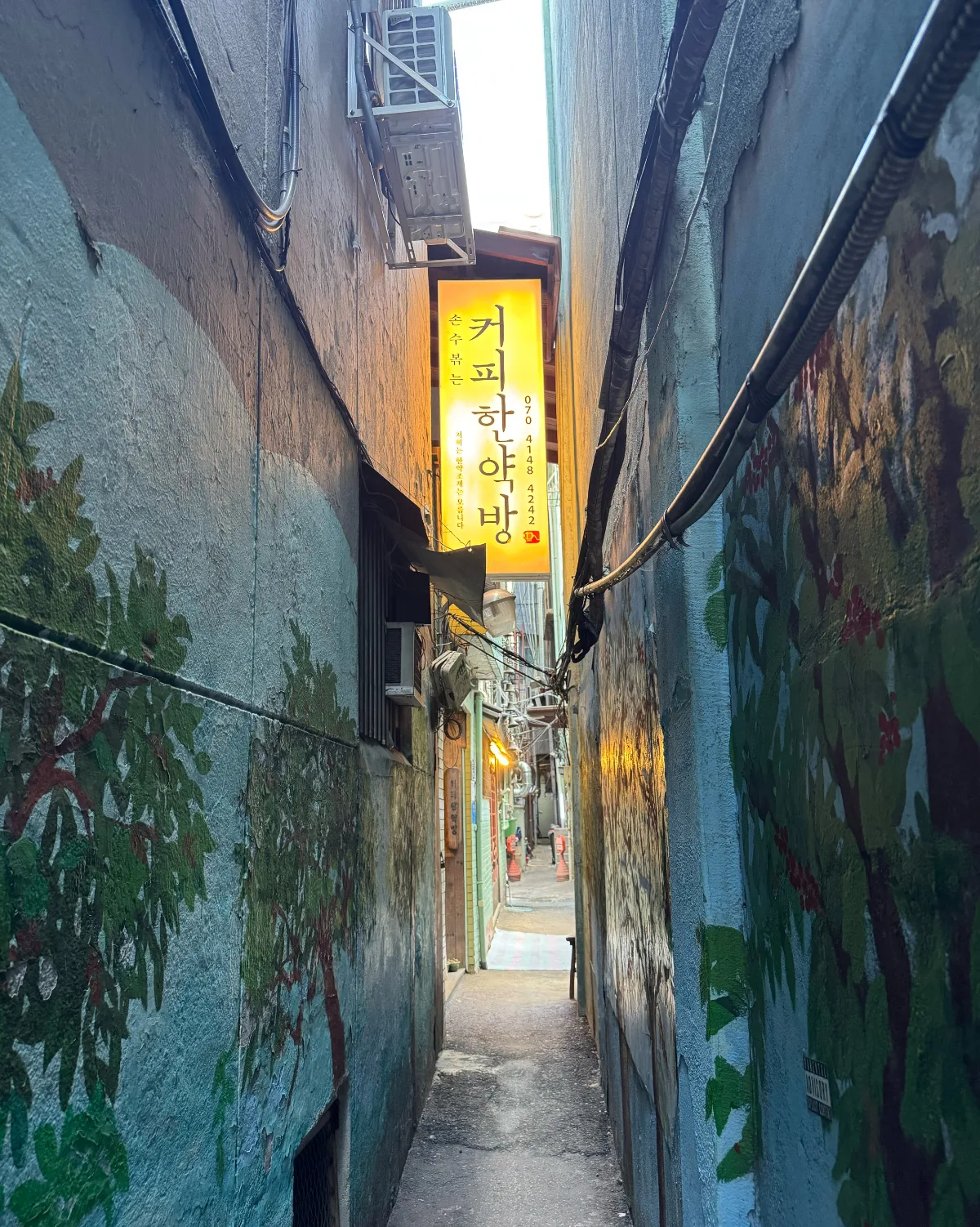 細い路地に掛かる店の看板