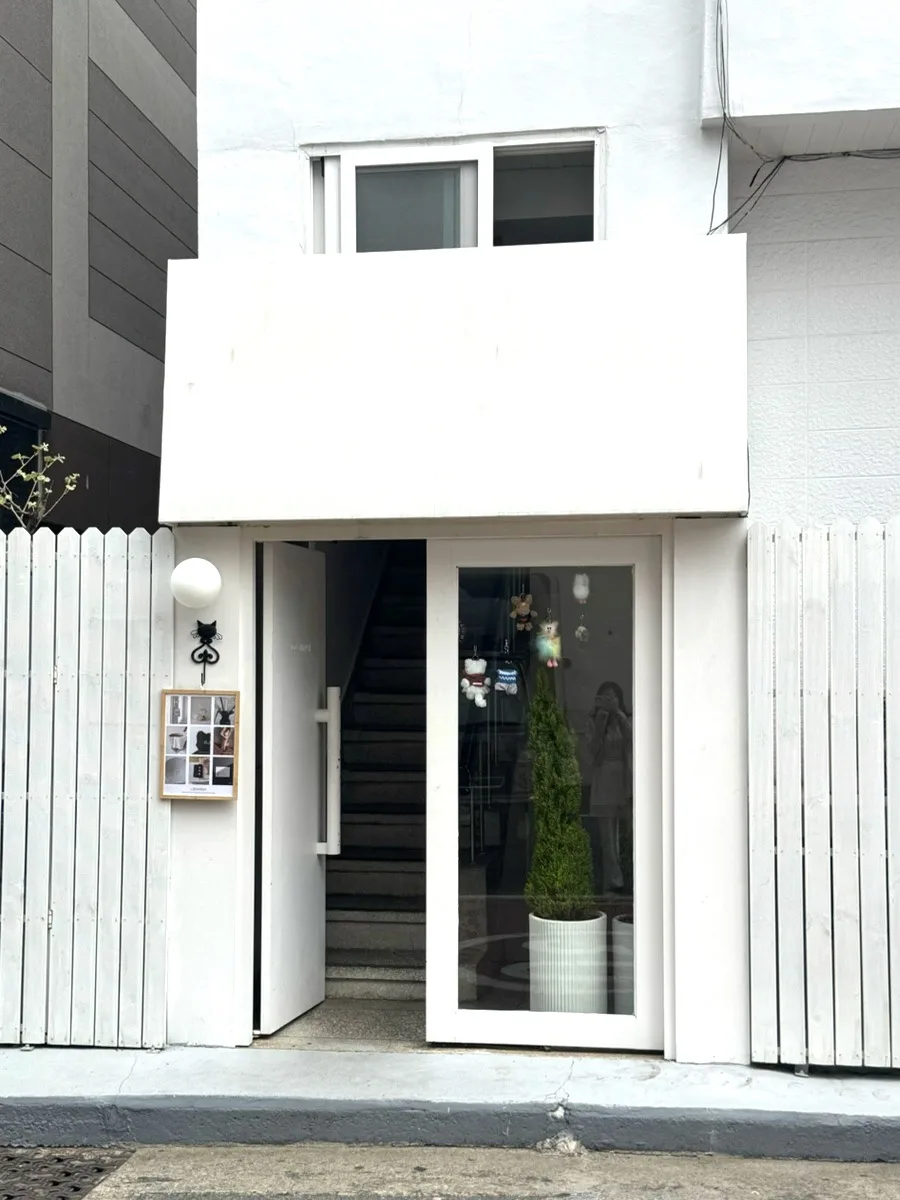 COSYMOSY 釜山店 — 白い入口の奥に続く階段