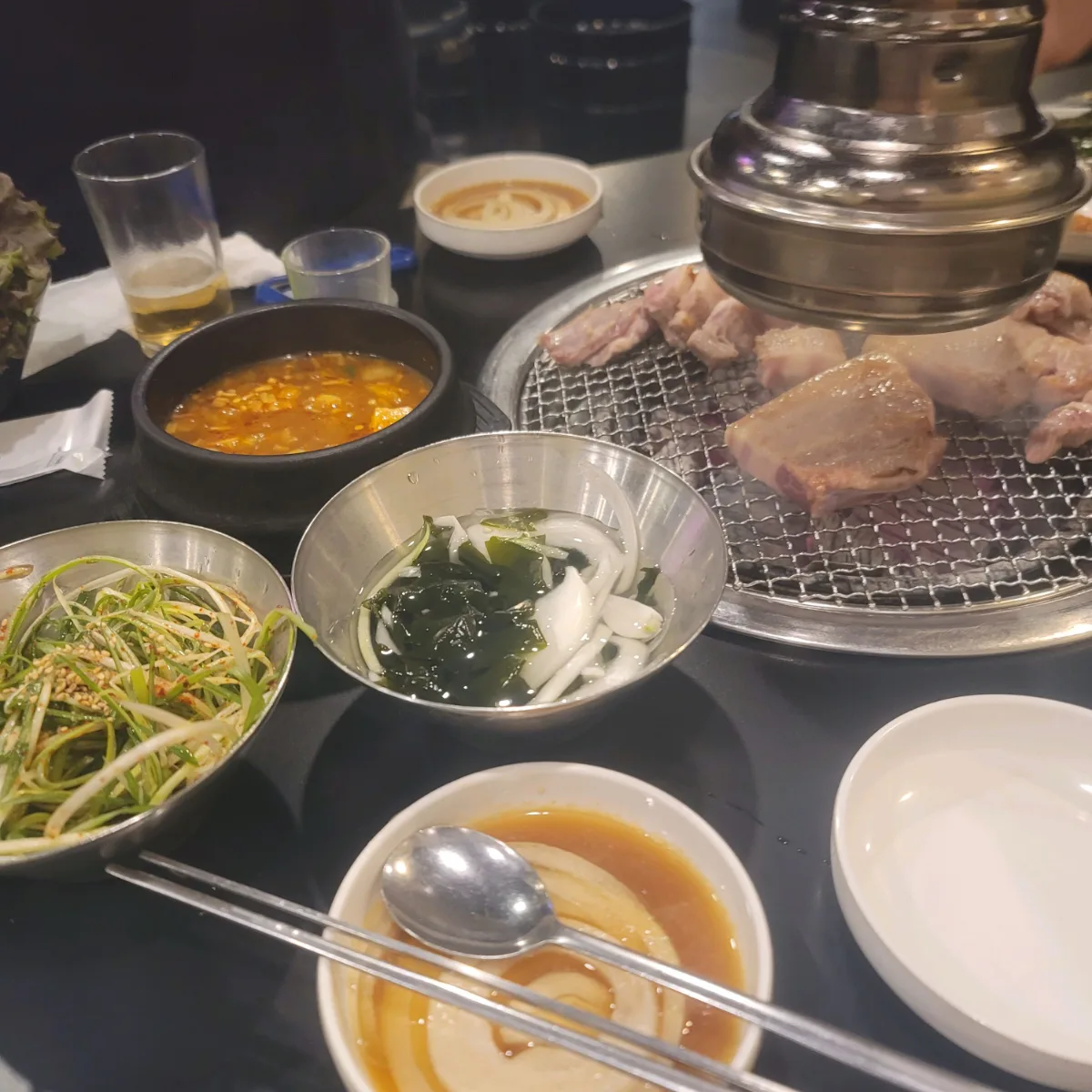 タドギネ・スップルクイ 本店 — 焼肉と副菜が並ぶ食卓