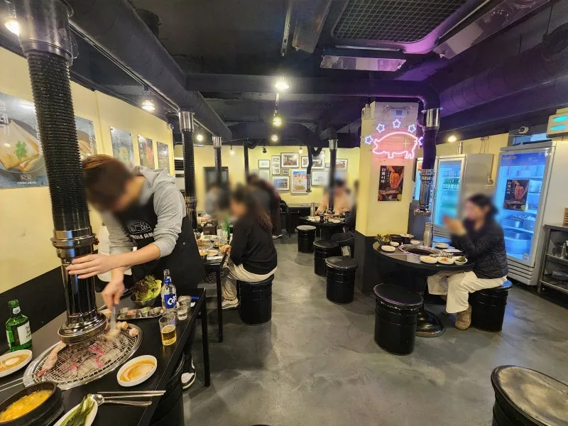 炭火焼きの卓が並ぶ店内