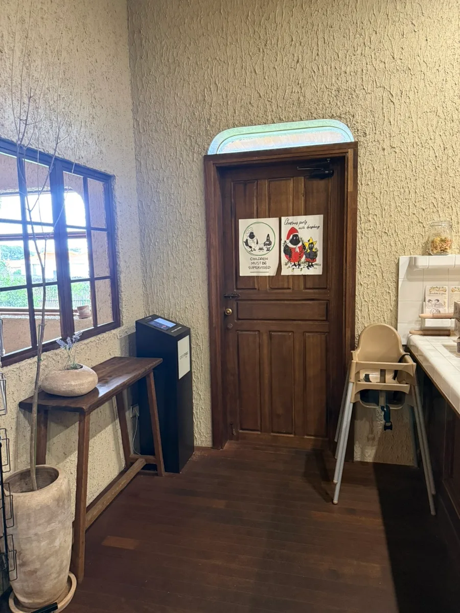 木の扉の横に置かれたベビーチェア