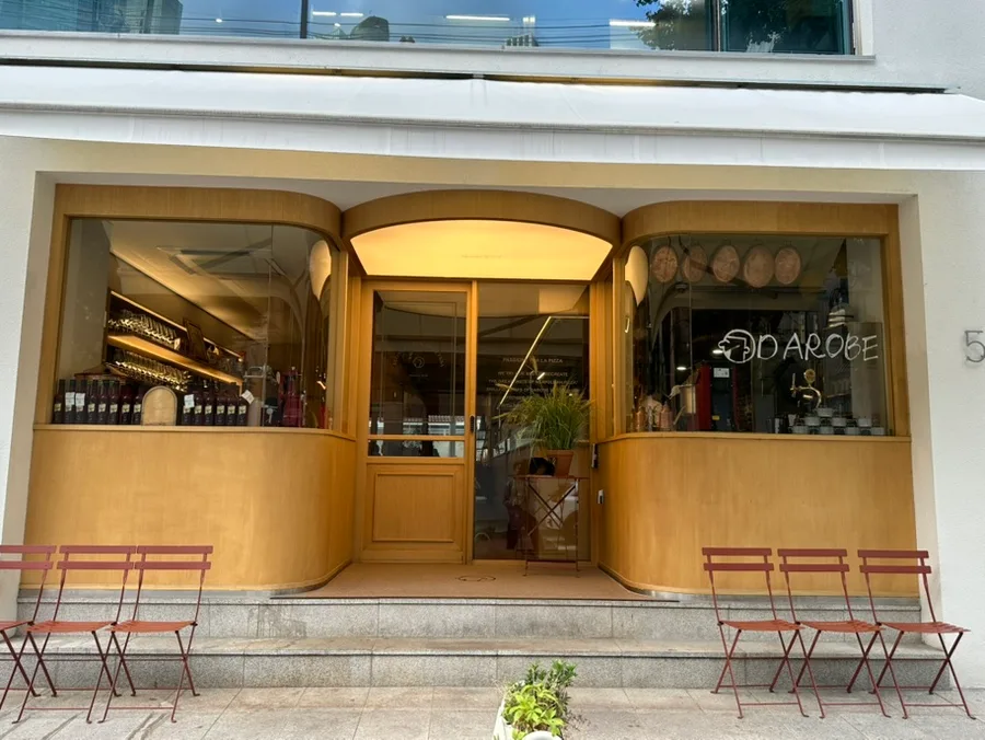 ダロベ 聖水店 — 木枠の入口と赤い椅子