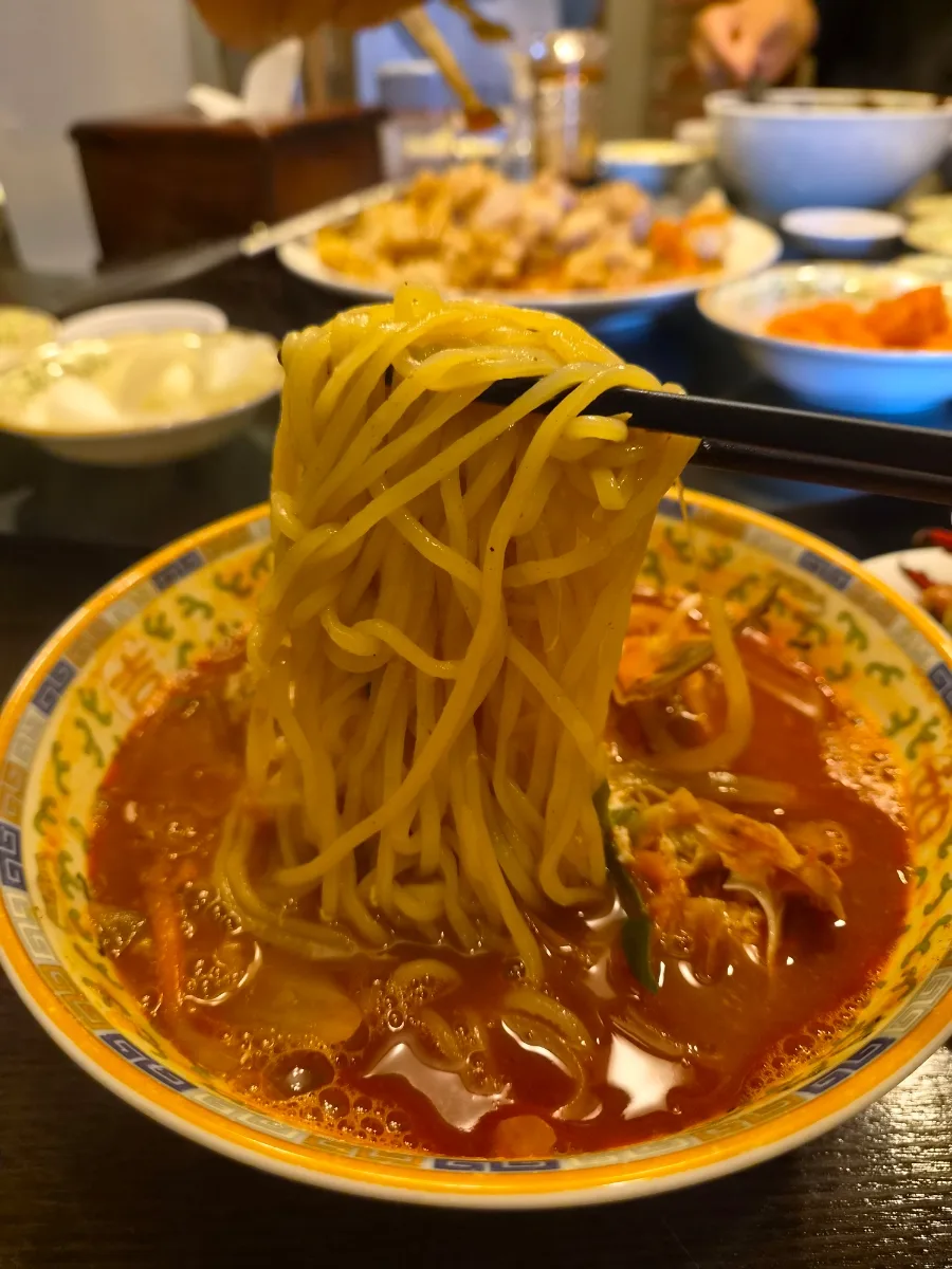 赤いスープから持ち上げた麺