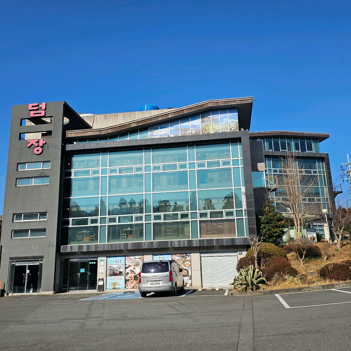 トムジャン 中文店 — トムジャンの看板とガラス張りの建物