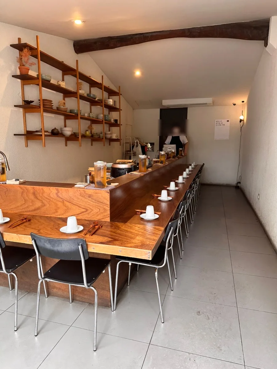 東亜食堂 — 木のカウンターと器の棚