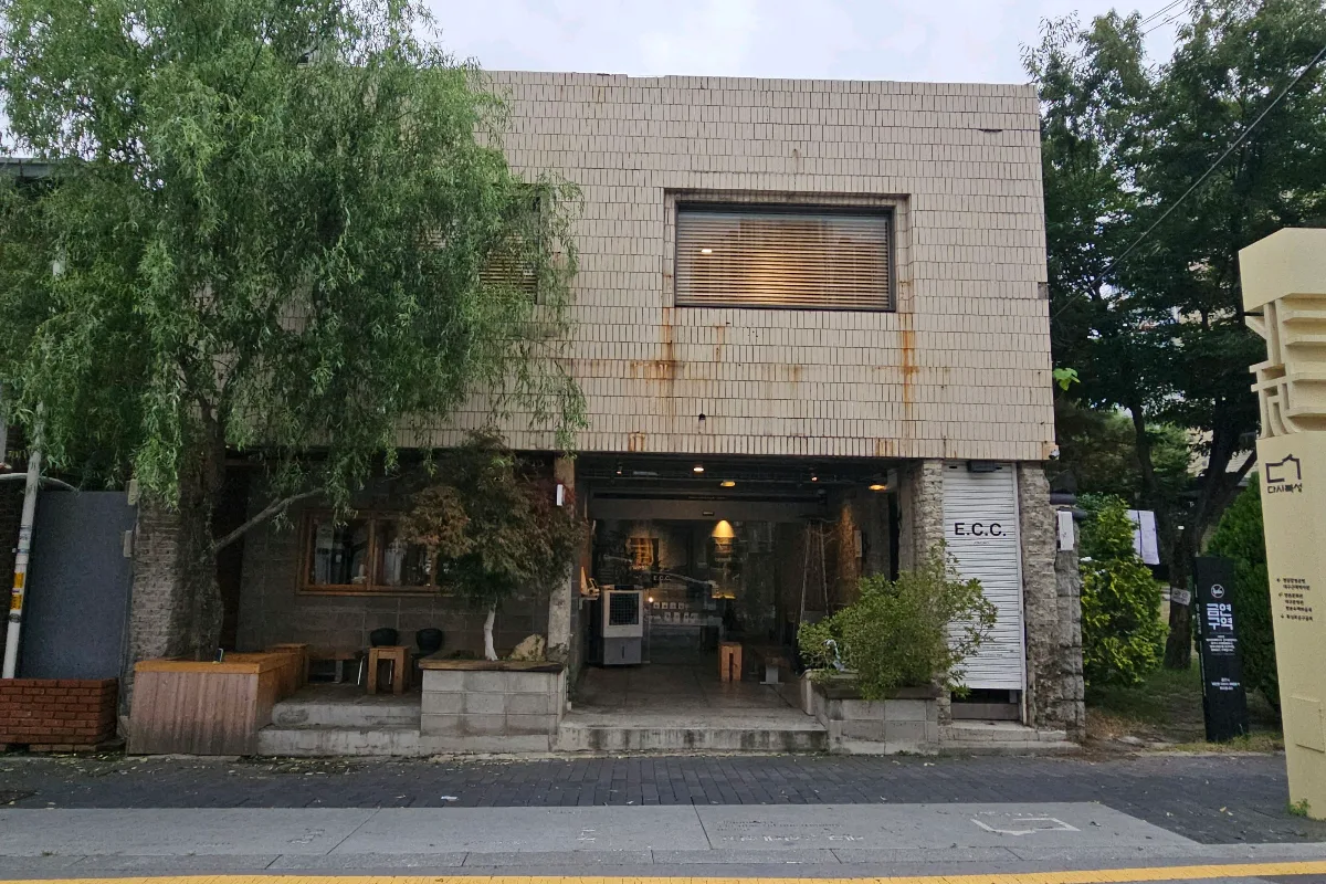 ECC COFFEE — 木々に囲まれたタイル張りの建物