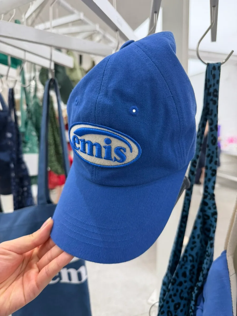 emis 明洞店 — 楕円のロゴを刺繍した青いキャップ