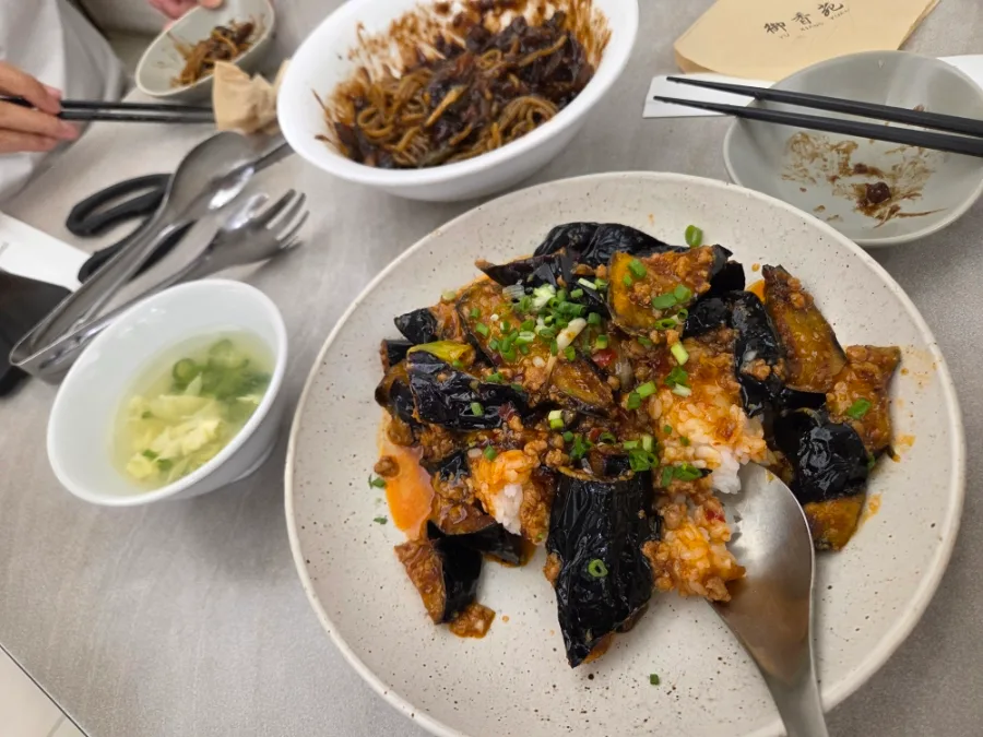 ご飯にのった魚香ナスと卓上のスープ