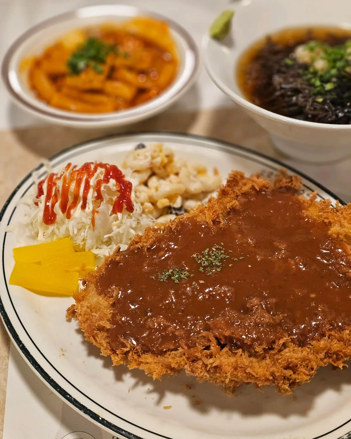 とんかつと奥に見える冷たいそば