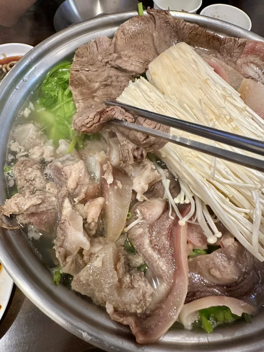 澄んだスープで煮る牛肉とエノキ