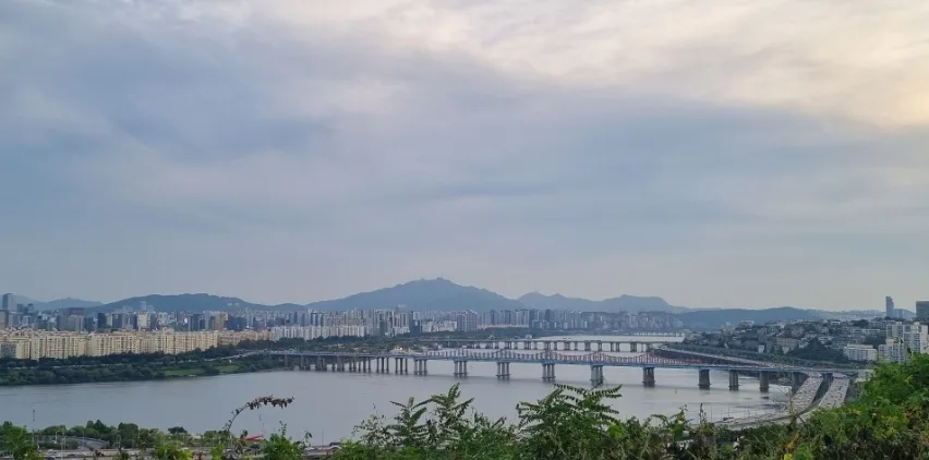 明るい空の下に広がる漢江と橋