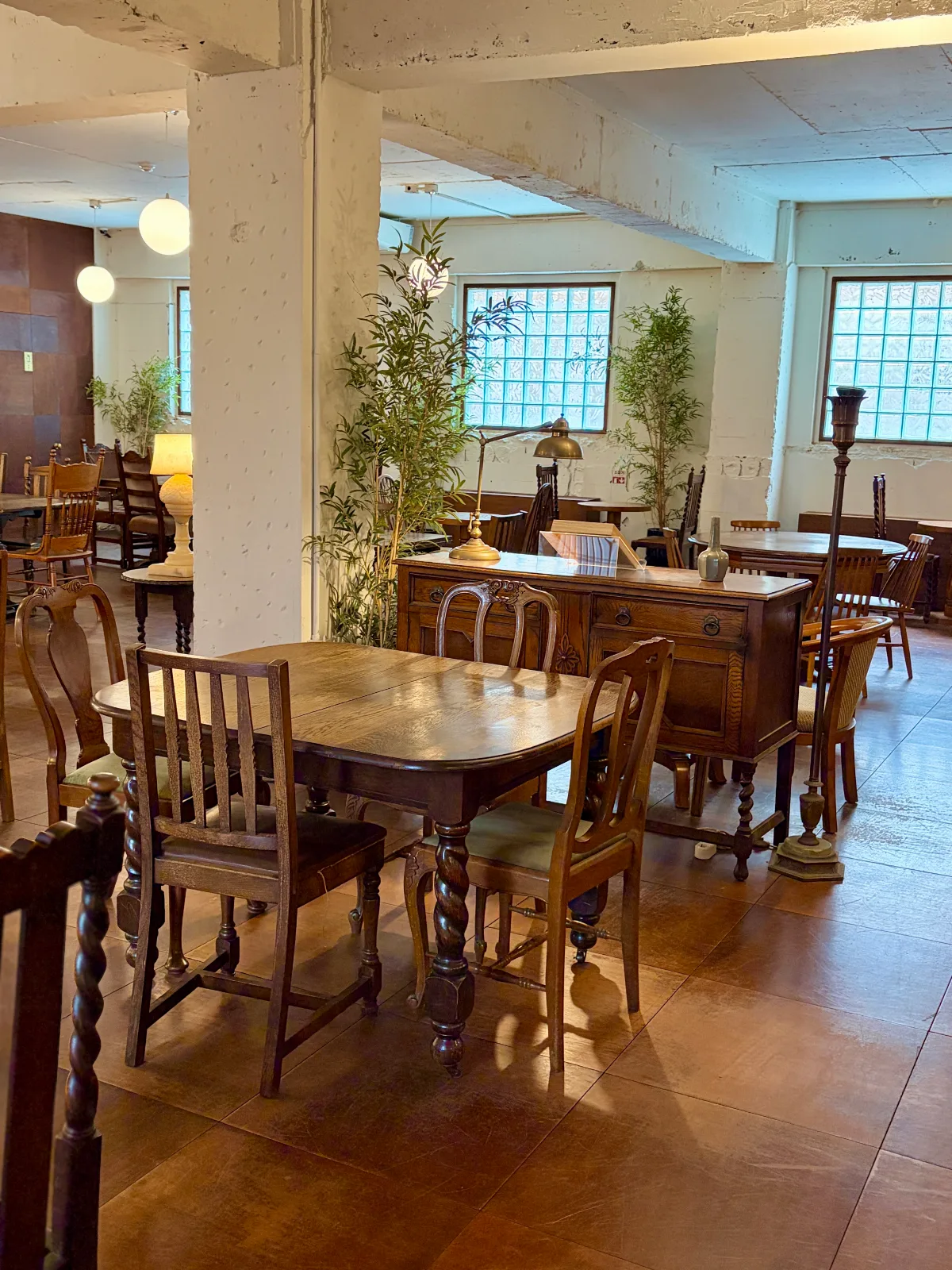 木のテーブルと椅子が並ぶ明るい店内