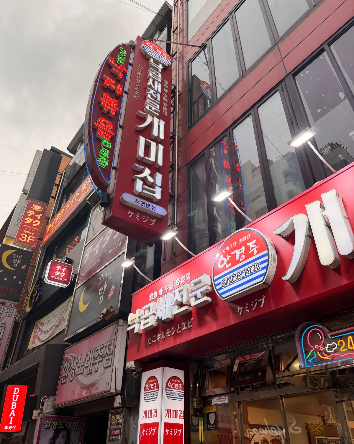 赤いネオン看板が並ぶ店の外観