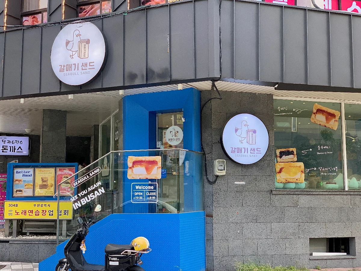 カルメギサンド 釜山本店 — カモメの丸看板と青い入口