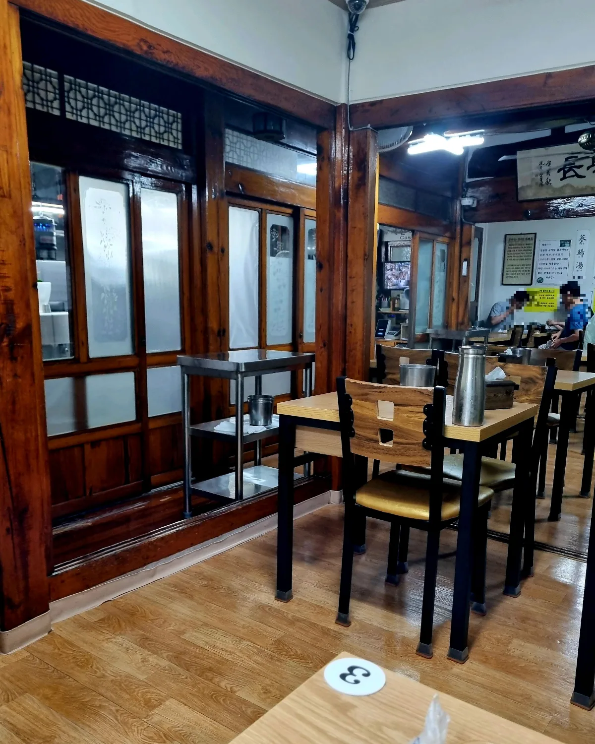 江原亭 — 木の柱とテーブルが並ぶ店内