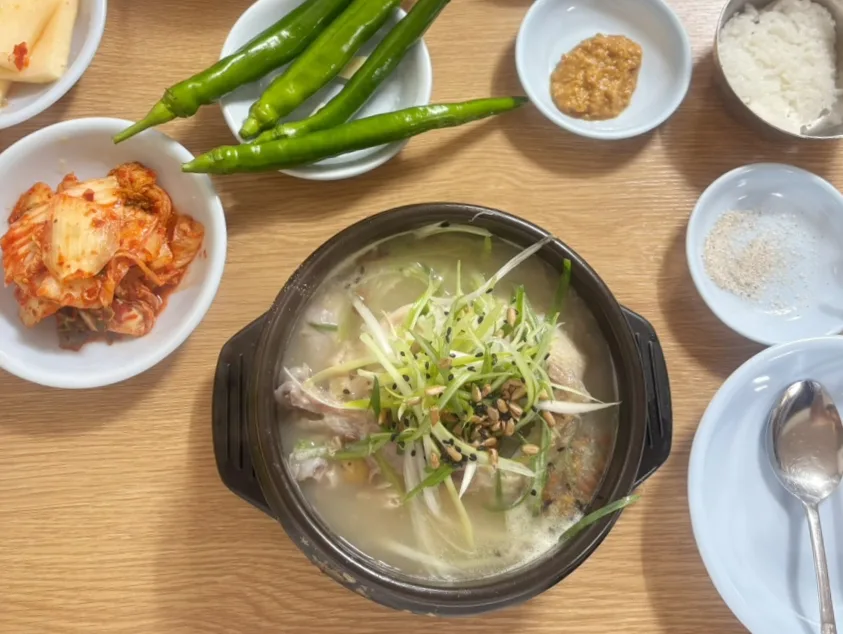 江原亭 — 鶏のスープとキムチが並ぶ食卓