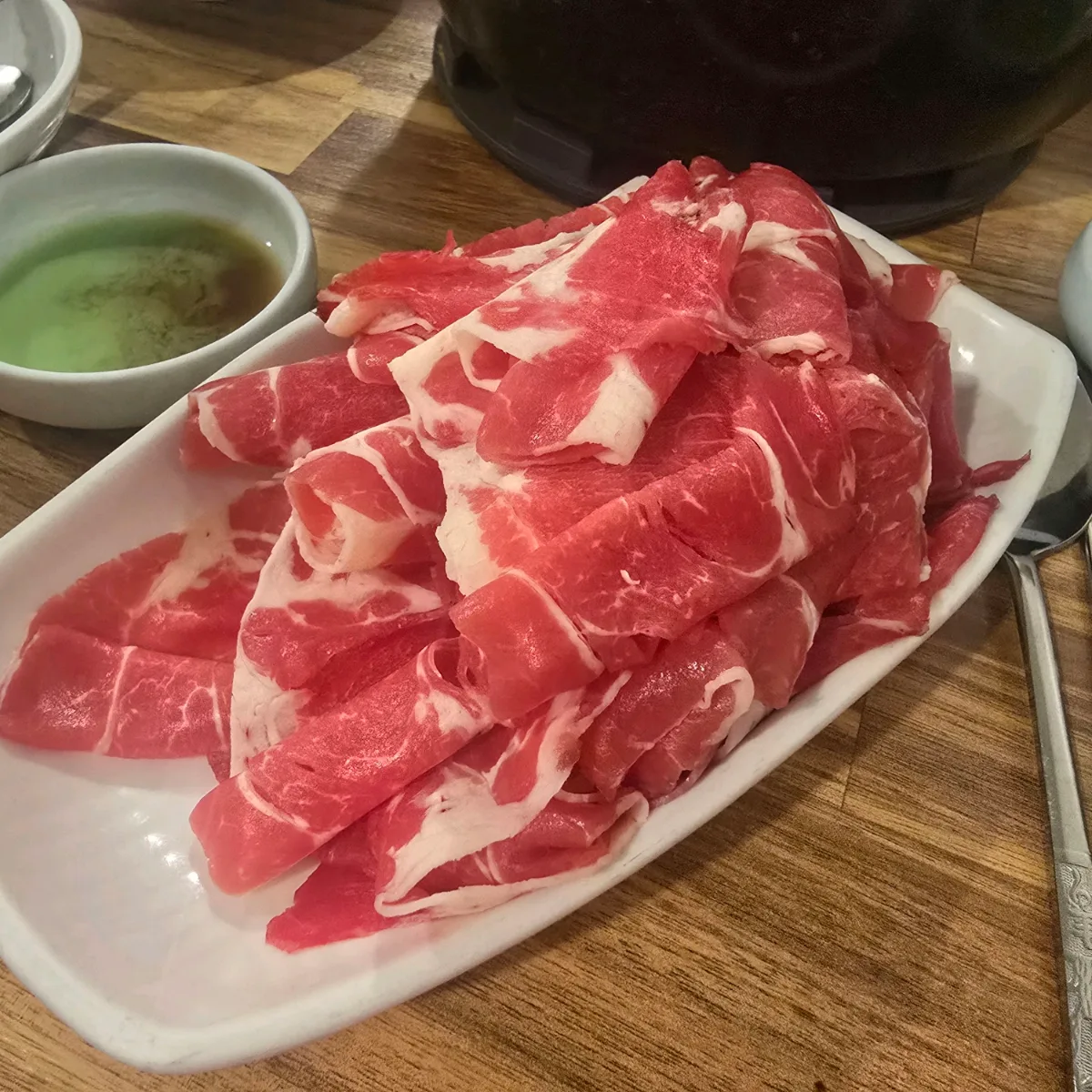 カヤン・カルグクス・ポソッメウンタン — 皿に盛られた薄切り牛肉