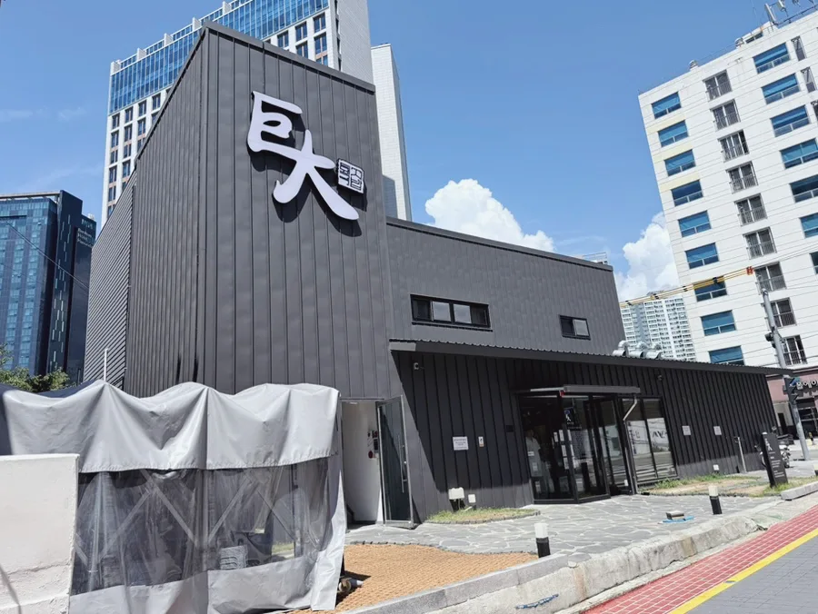 巨大テジクッパ — 大きな看板を掲げた黒い店舗