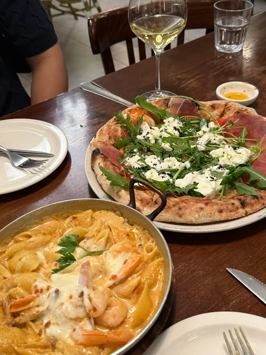 Giani's Napoli 駅三本店 — ピザとエビのパスタが並ぶ食卓
