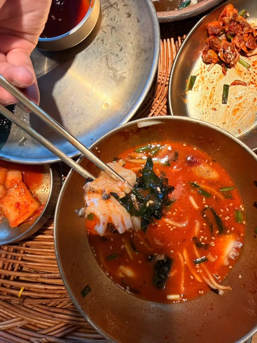 赤いムルフェを箸ですくうところ