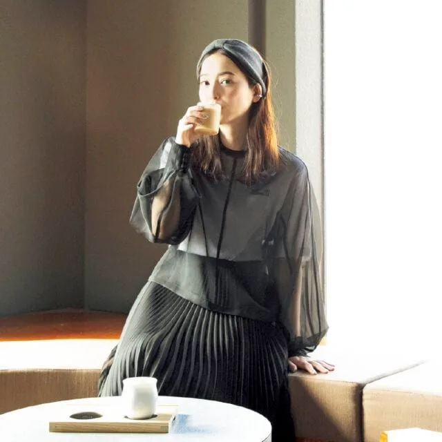 ソファ席でラテを飲む佐々木希さん(宝島社『InRed』2025年1・2月合併号より)