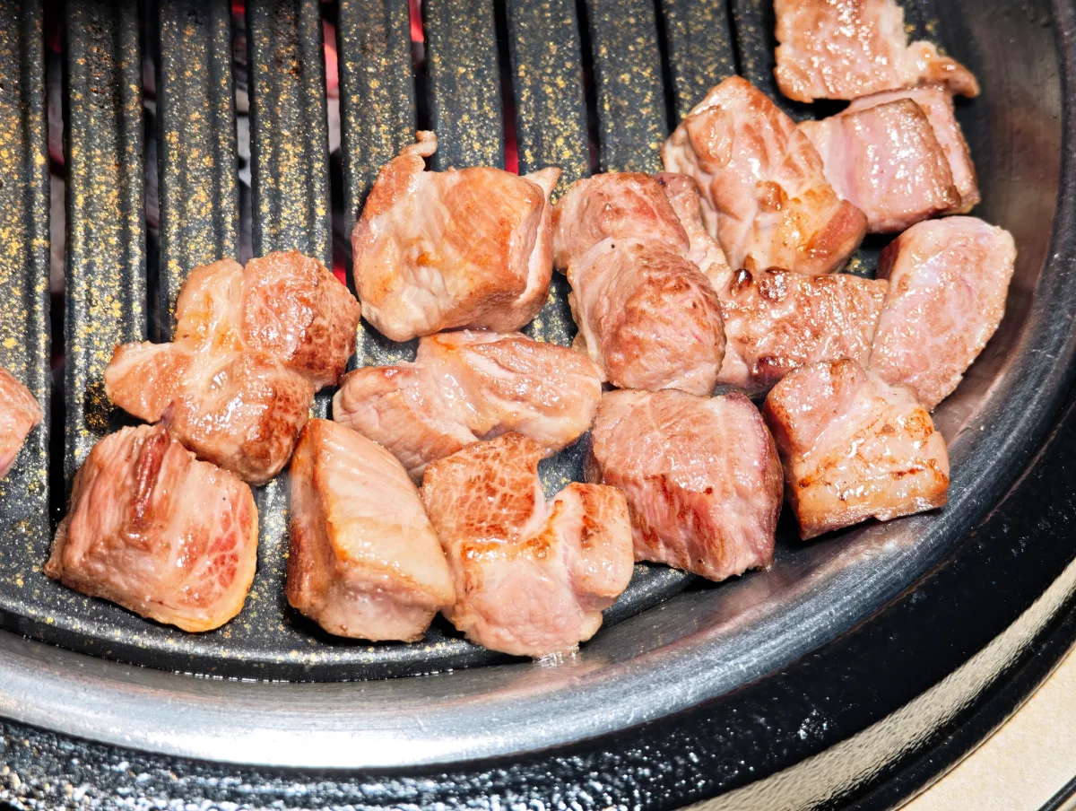 BBQ YUL 本店 — 網で焼かれる厚切りの豚肉