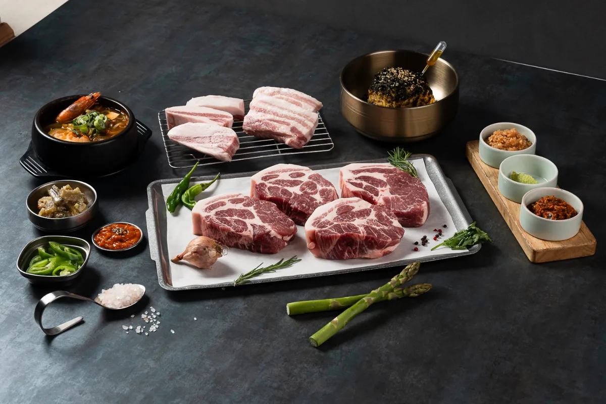 BBQ YUL 本店 — 豚肉とおかずが並ぶ食卓