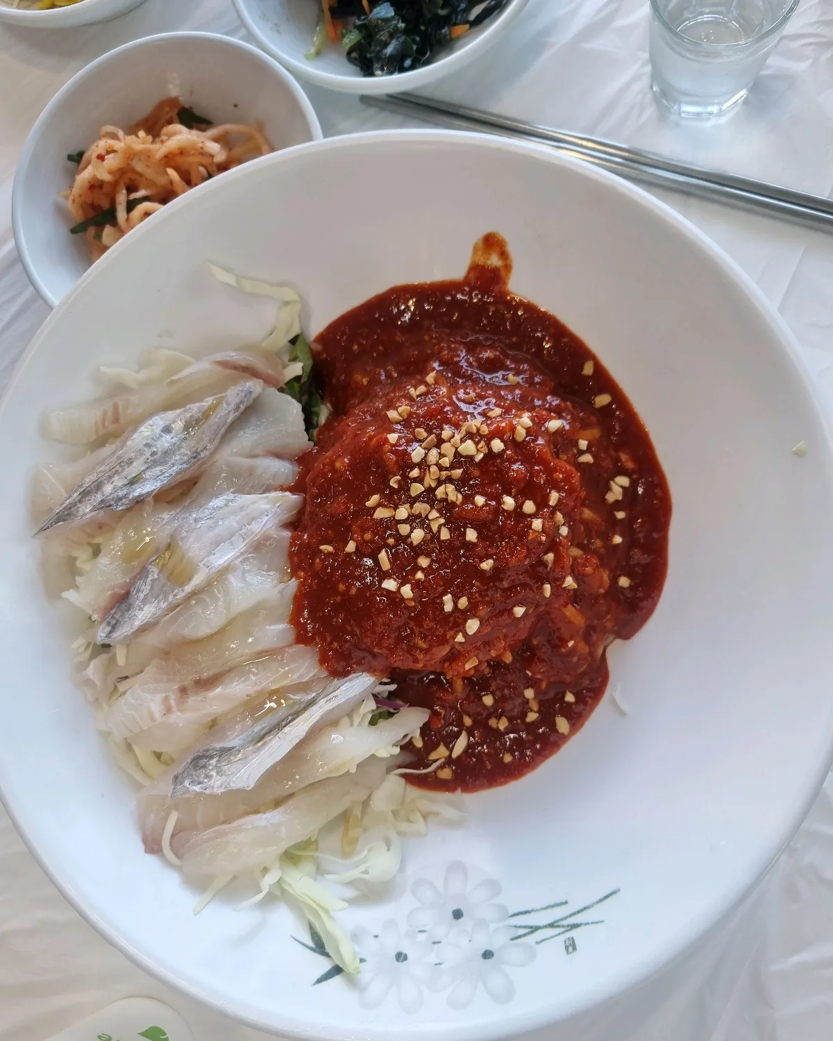 刺身と野菜に赤いたれを添えた麺