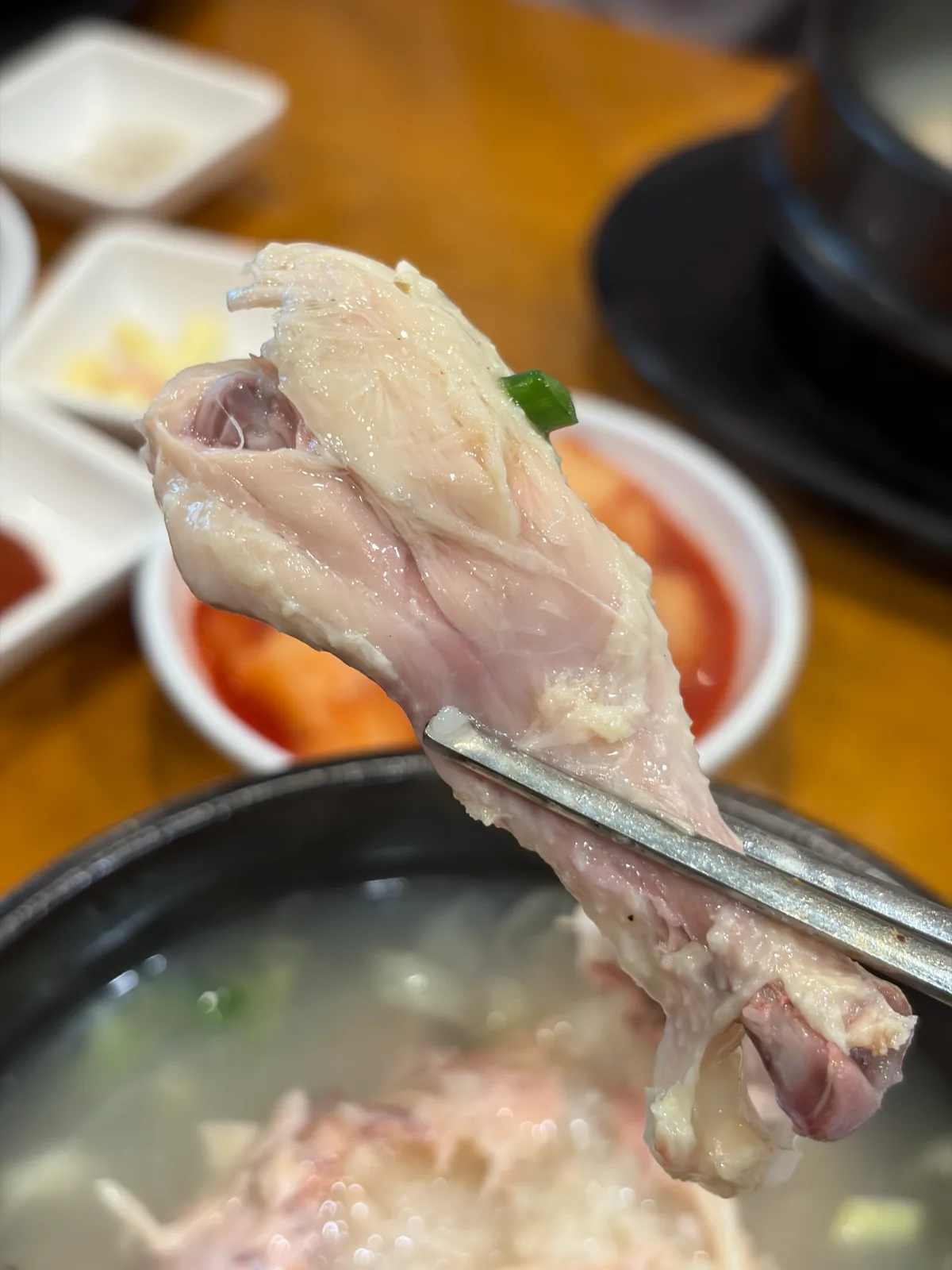 箸で持ち上げた鶏のもも肉