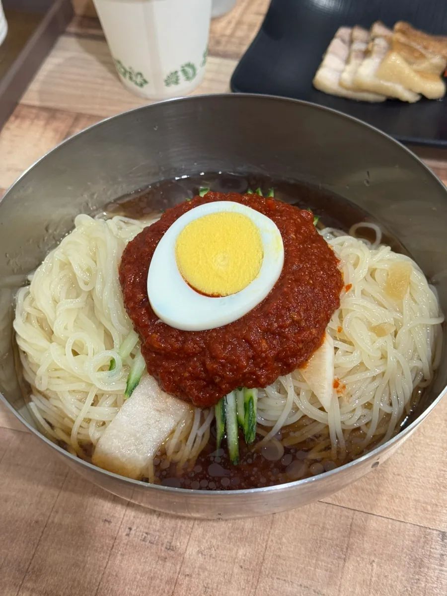 赤いたれとゆで卵をのせたミルミョン