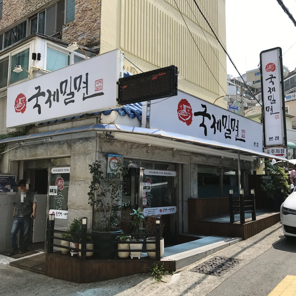 国際ミルミョン 本店 — 国際ミルミョン本店の白い看板