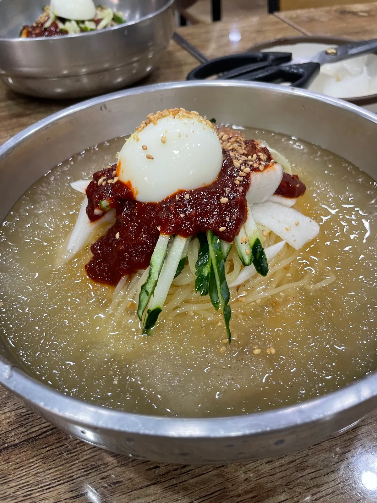 赤いたれと卵をのせたムルミルミョン