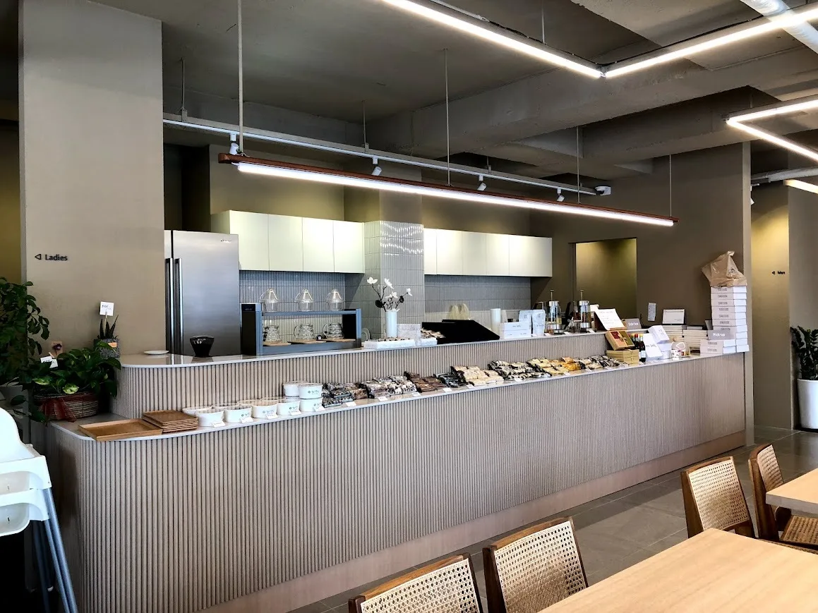 京畿餅屋 — 餅が並ぶカウンターと木のテーブル
