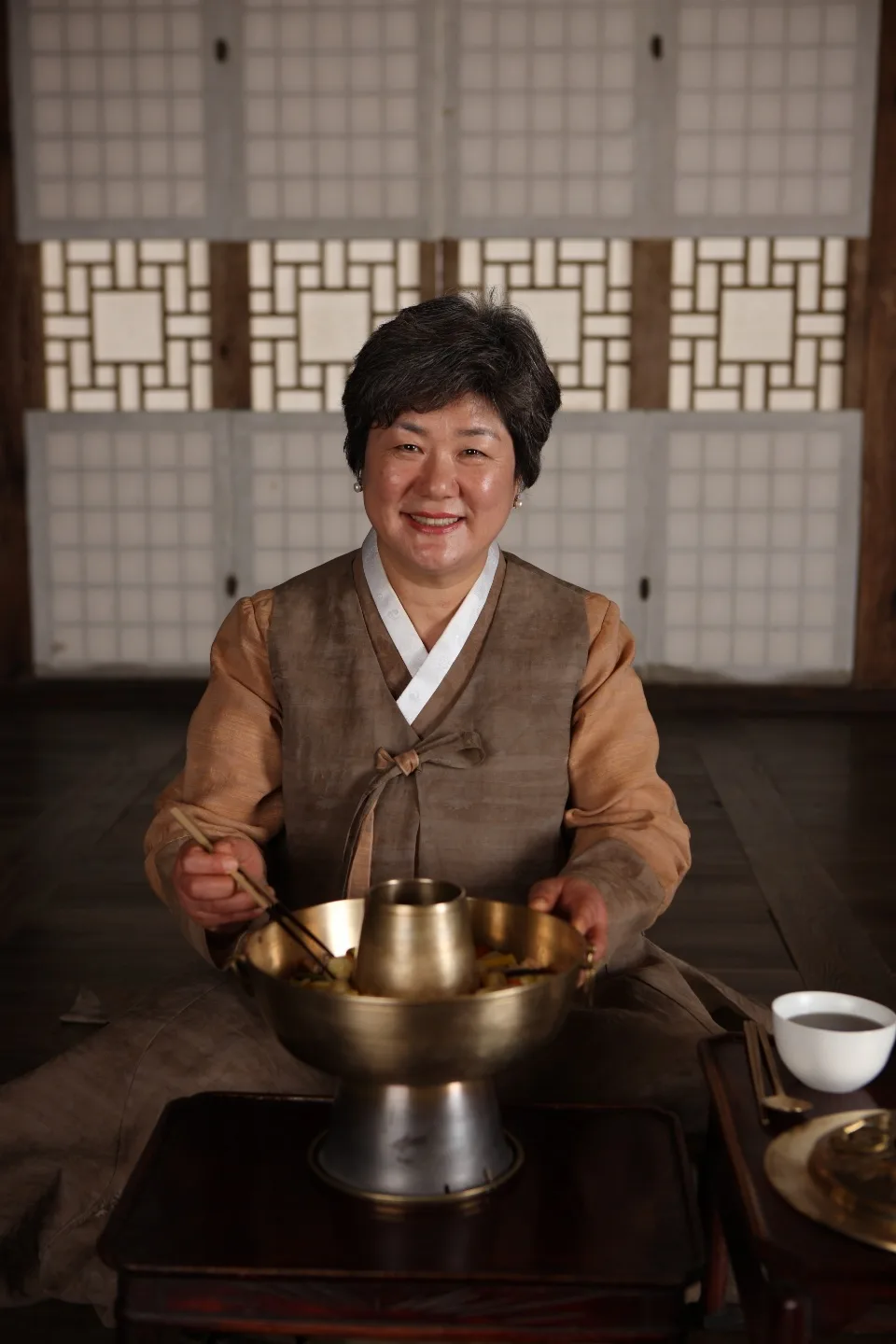 韓屋の座敷で器を前にするパク・ミスクさん
