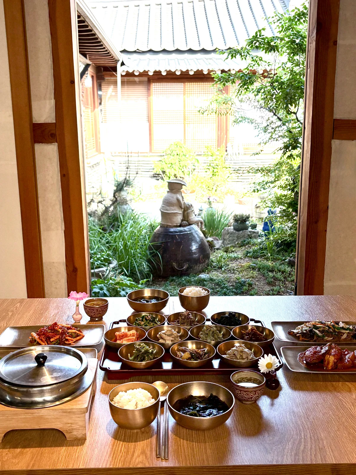 スリメ — 庭が見える窓辺に並ぶ韓定食の膳