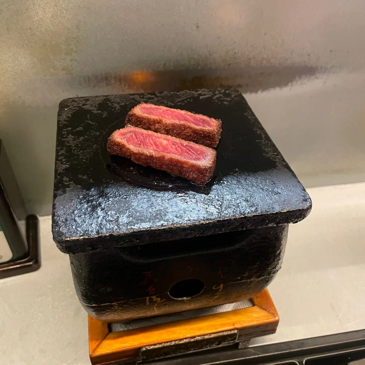 焼き台にのせたレアの牛カツ