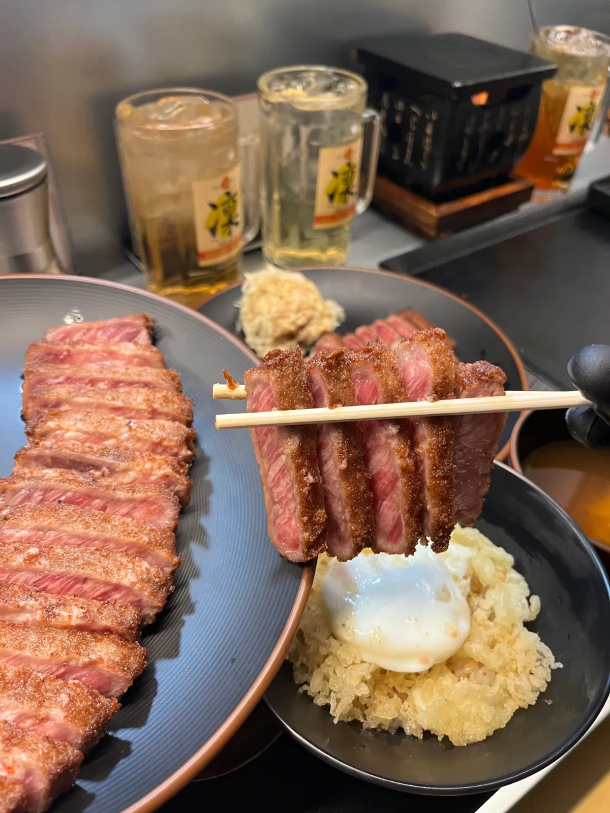 牛かつ亭 延南店 — 箸で持ち上げたレアの牛カツとたまご天丼