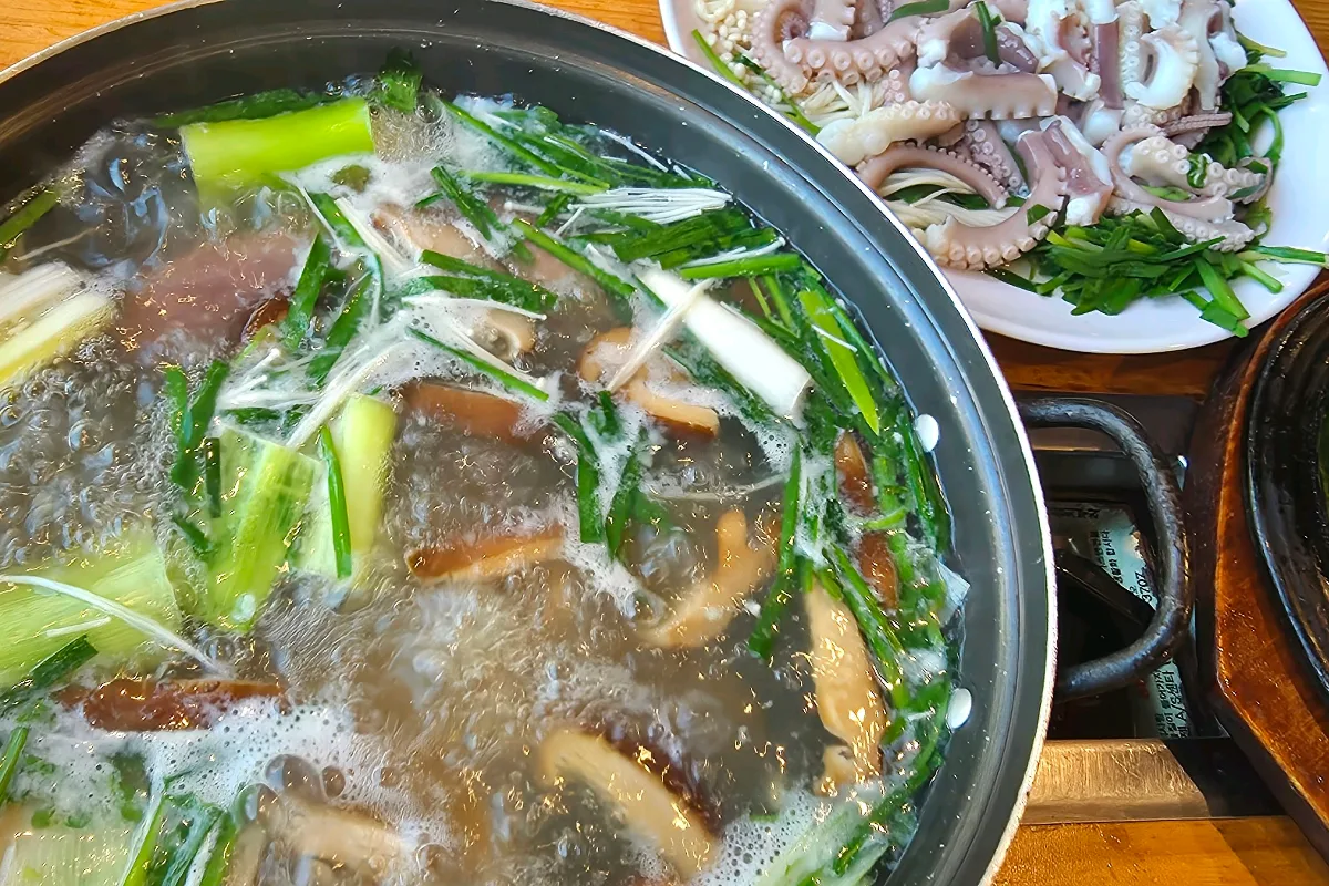 野菜の鍋と切り分けたタコ