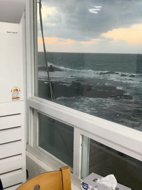 窓のすぐ向こうに広がる海と岩場