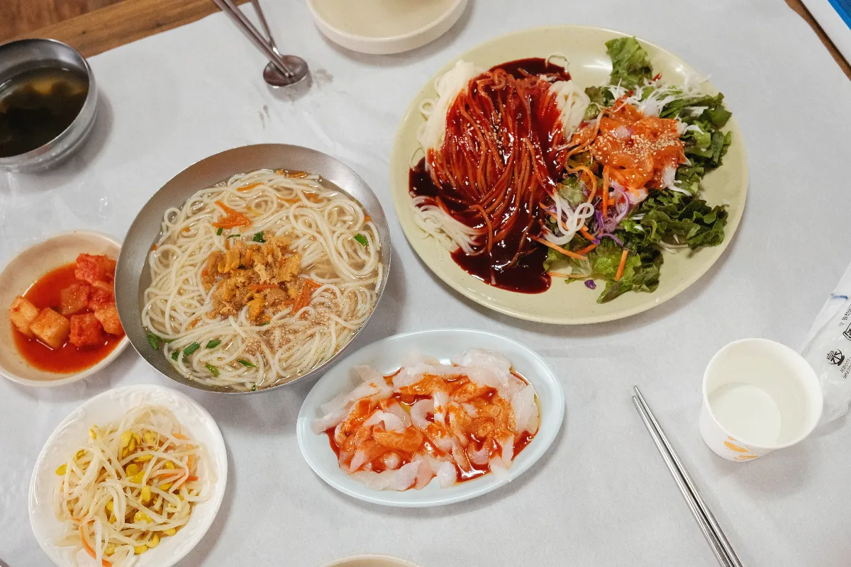 海女村 — 汁麺と刺身、混ぜ麺が並ぶ食卓