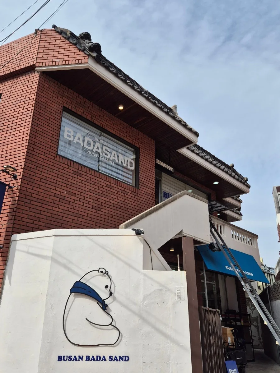 瓦屋根の建物に入るBUSAN BADA SAND