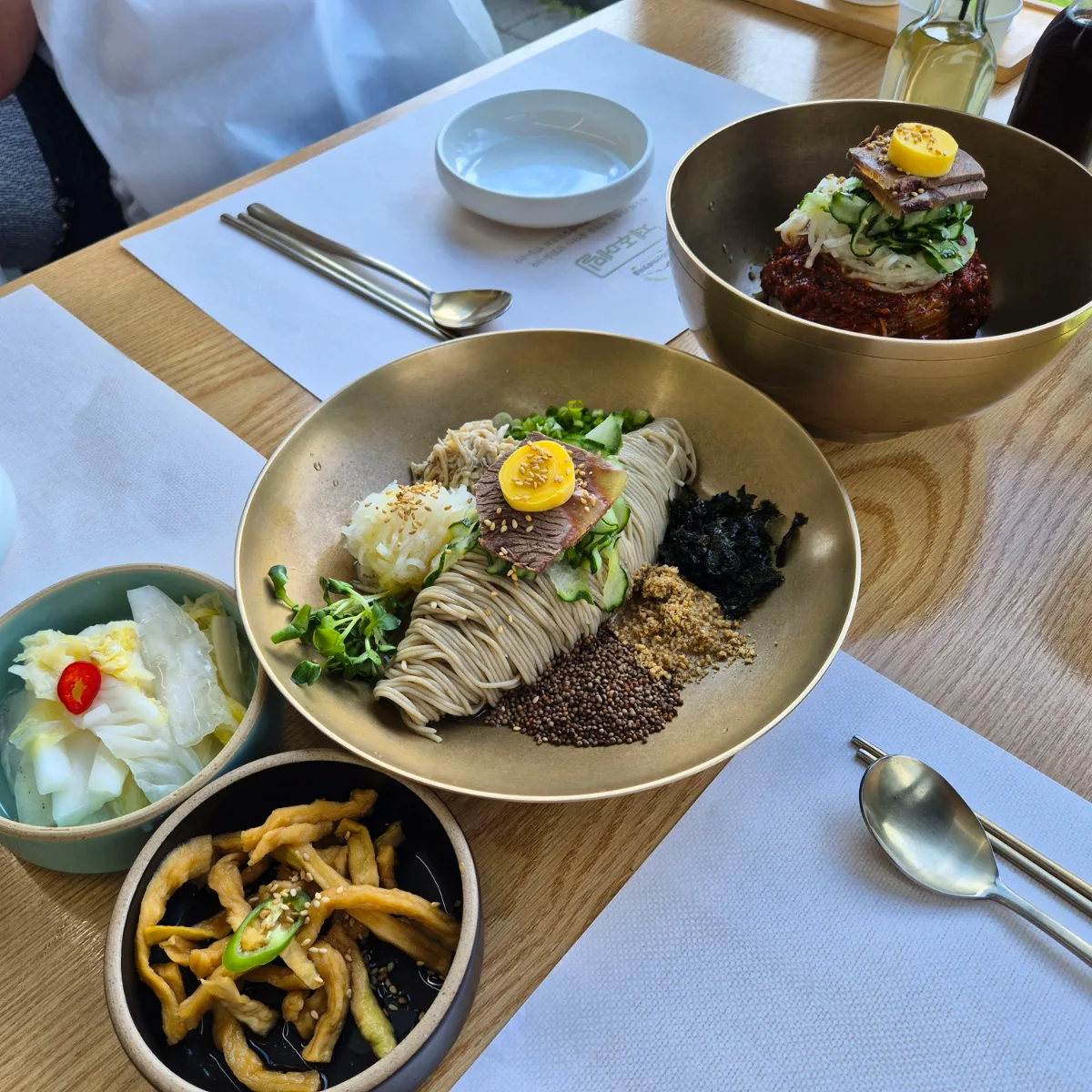 ハルラサンアレチョンマウル 本店 — そば麺と小鉢が並ぶ食卓