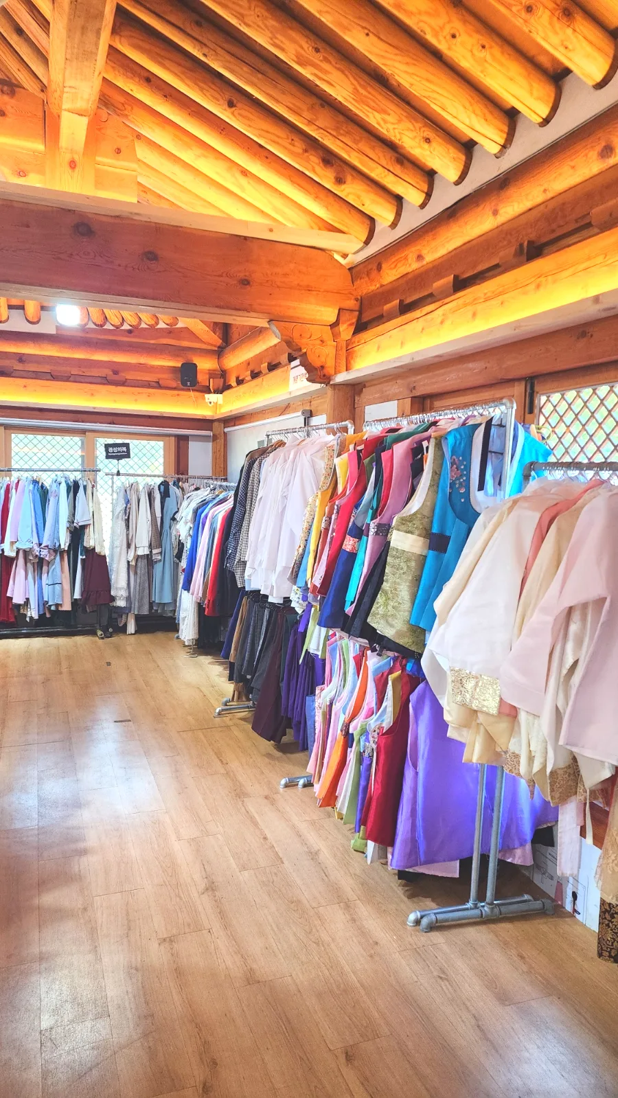 韓服男 全州韓屋村店 — 木の梁の下に並ぶ韓服