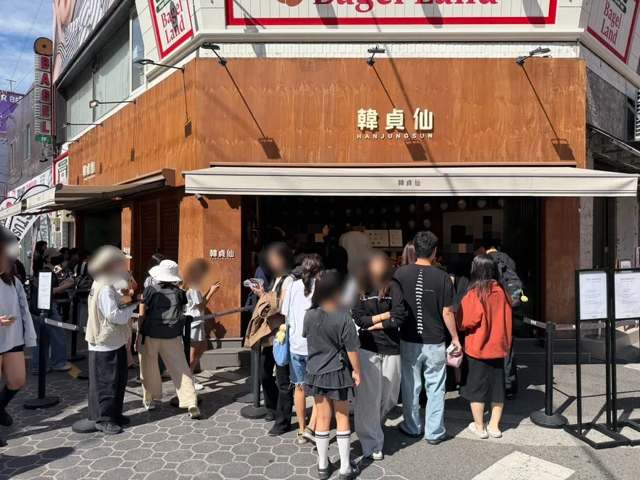 韓貞仙 聖水本店 — 韓貞仙の木の外壁と店先の列