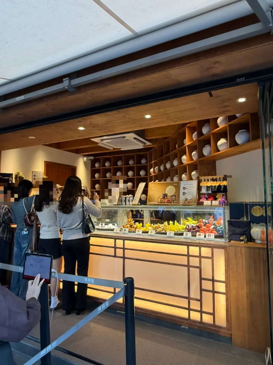 韓貞仙 聖水本店 — 白い壺が並ぶ木造の販売カウンター