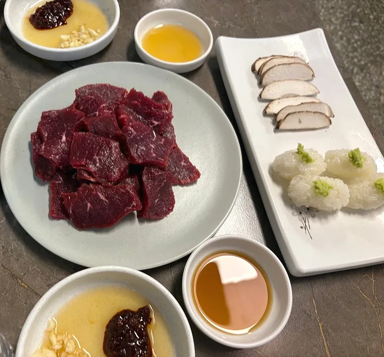 ハンムンティギ — 牛刺しと薬味が並ぶ食卓