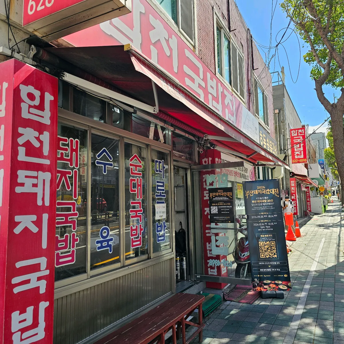 歩道沿いに並ぶ赤いクッパ店の看板