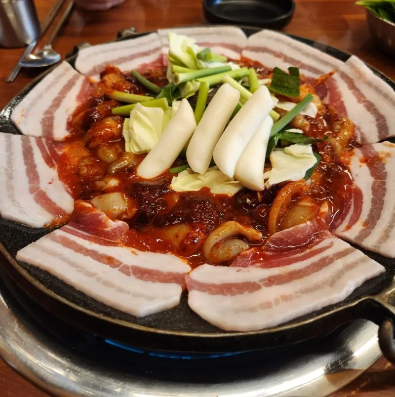 チュクミのまわりに豚バラ肉を並べた鉄板