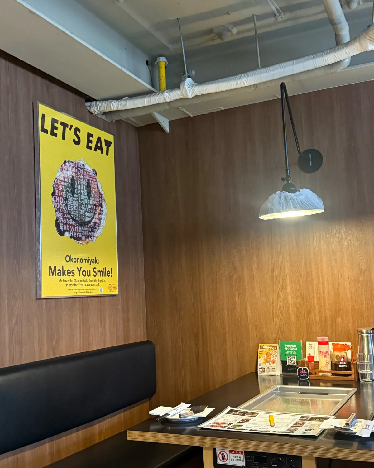 HOTCHO 本店 — 鉄板付きテーブルが置かれた木目のボックス席