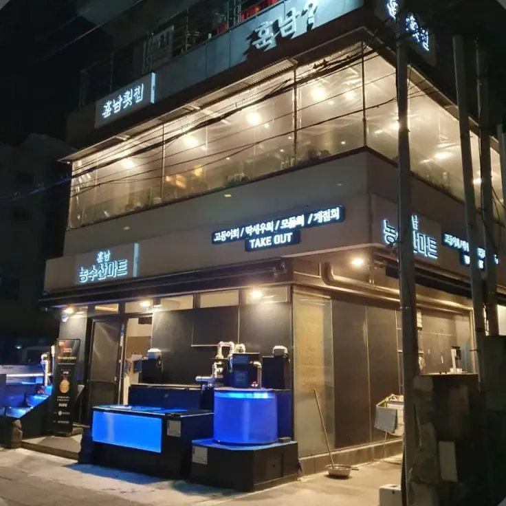 フンナム刺身店 — 青く光る水槽と店の看板